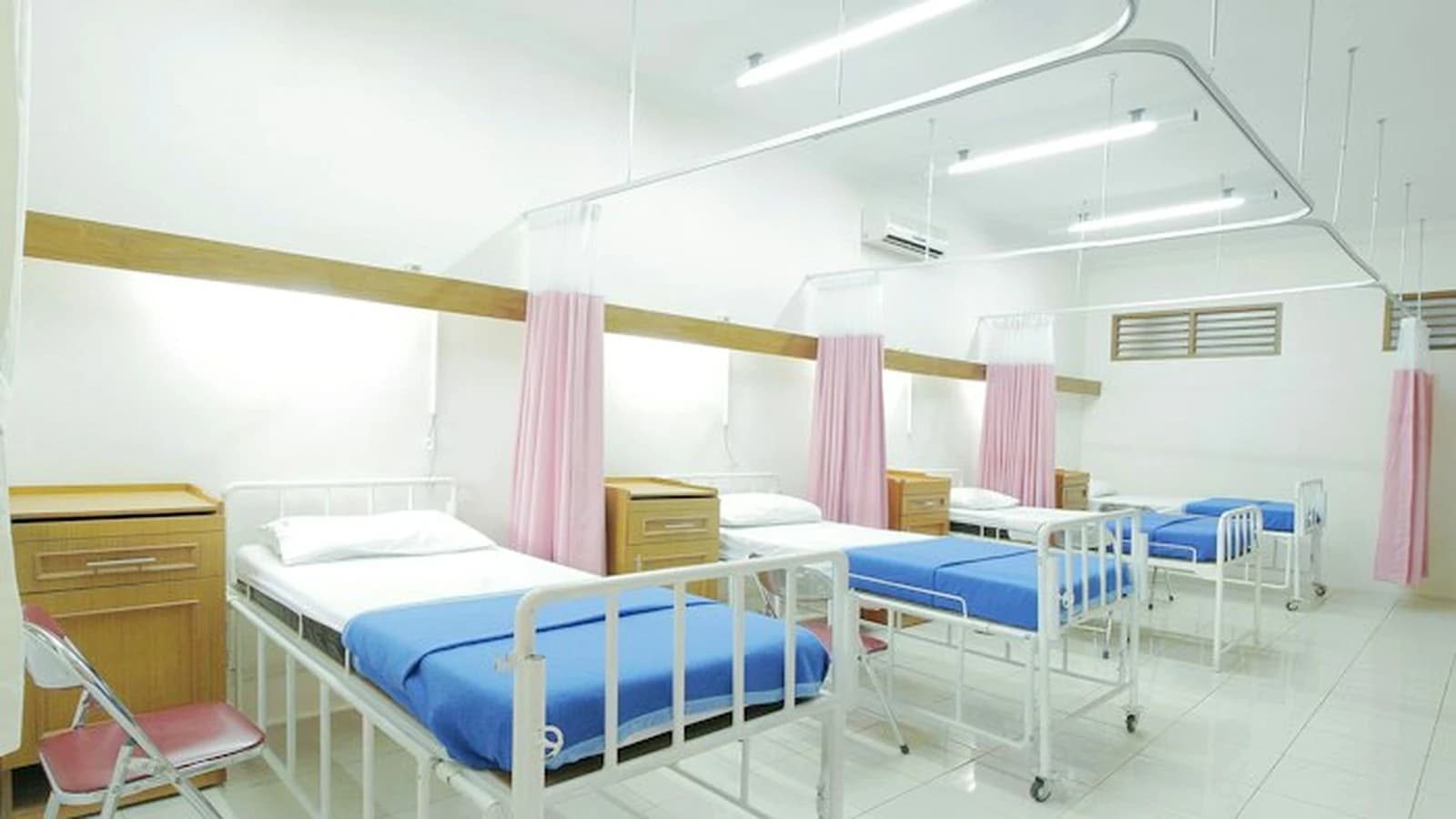 Modern bright inpatient hospital facility with clean clinical beds and patient monitoring